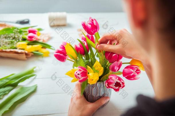 不面容年幼的男人制造春季花束使用郁金香.在线的自己