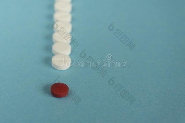 num.一红色的药丸和许多白色的和黄色的药丸s向蓝色背景