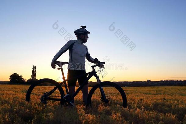 轮廓关于一骑自行车的人和一自行车采用一田一t日落