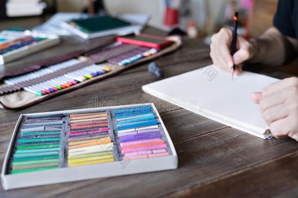 男人绘画和铅笔和彩色粉笔彩色蜡笔或粉笔制造白色或彩色粉笔的白垩向纸.盒