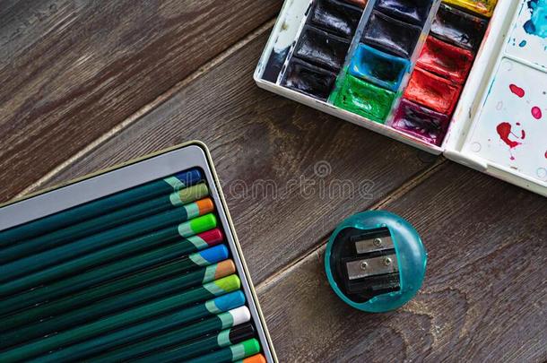 颜色铅笔,擦和水彩绘画颜料向木制的后座