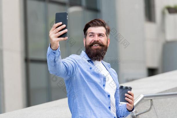 我的自拍照和我的电话.有胡须的男人拿自拍照和smart电话.