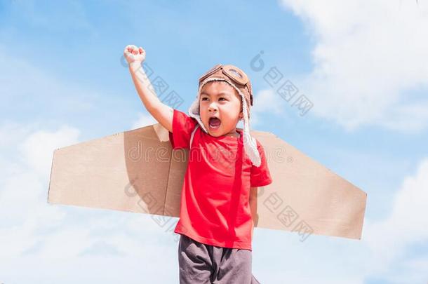 小孩小的男孩微笑穿着飞行员帽子比赛和玩具飞机翅膀