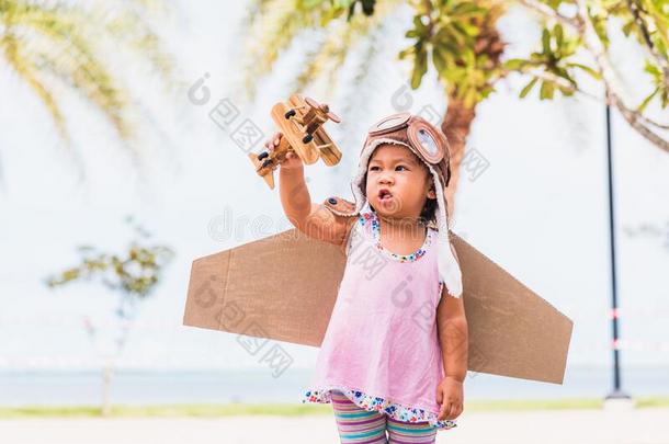 小孩小的女孩微笑穿着飞行员帽子和护目镜比赛玩具卡片式