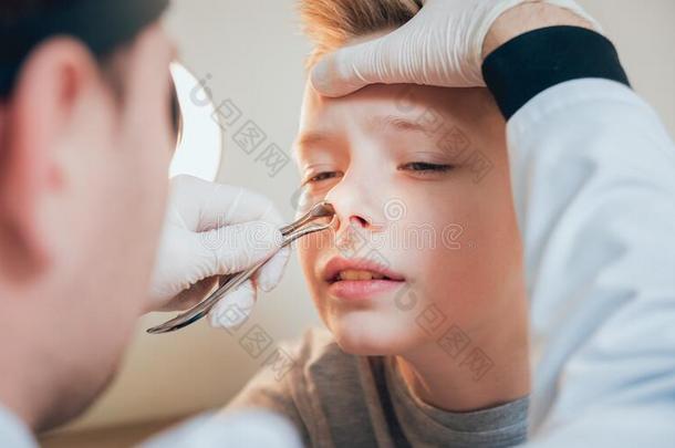 耳鼻喉科医师仔细检查男孩鼻子和纳索尔<strong>扩张</strong>器.