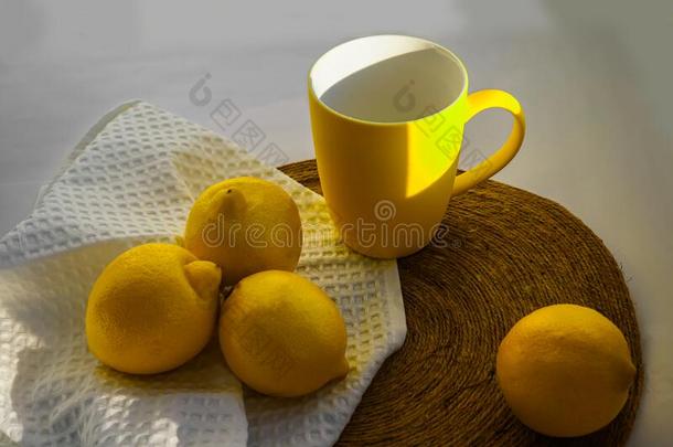 明亮的黄色的柠檬和一马克杯