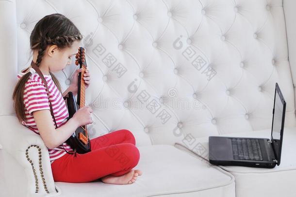 在线的教育.女孩学习向比赛吉他在家使用lap向