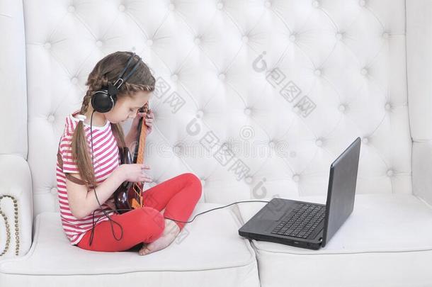 在线的教育.女孩学习向比赛吉他在家使用lap向