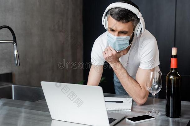 自由作家采用耳机和医学的面具look采用g在便携式电脑在近处