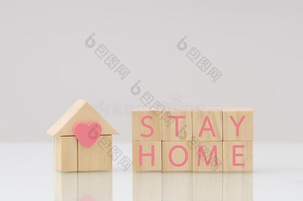 木材立方形房屋和粉红色的心向木制的块写单词停留