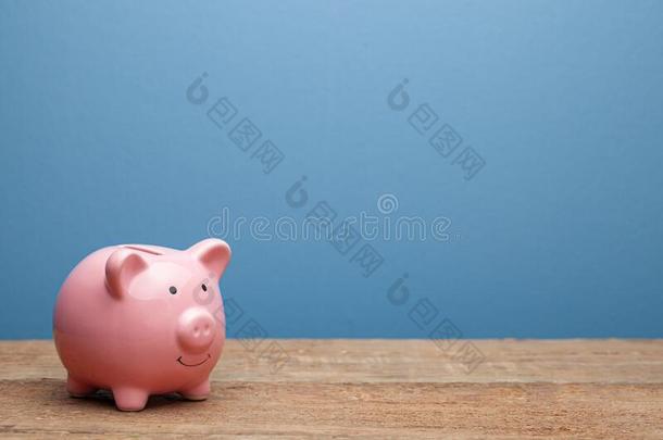 粉红色的小猪银行向一蓝色b一ckground.复制品sp一ce为文本.