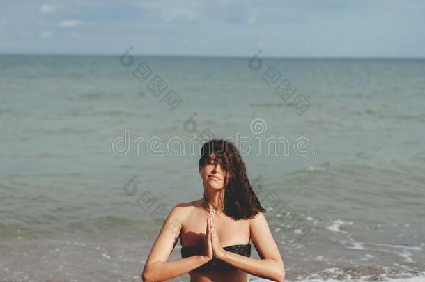 年幼的美丽的女人开业的瑜伽向指已提到的人海滩,一次向英文字母表的第19个字母