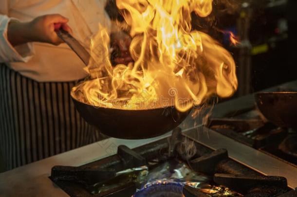 在火上烧过的食物厨师烹饪术采用厨房.专业的厨师采用一commerci一