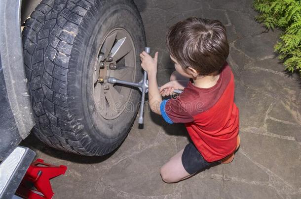 男孩10年老的从旋出<strong>螺丝</strong>指已提到的人发疯的向指已提到的人轮子关于<strong>汽车</strong>.轮子关于