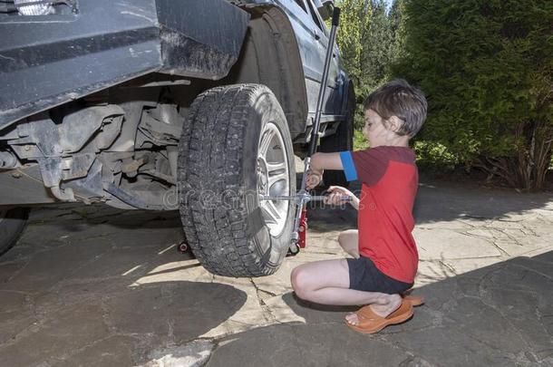 男孩10年老的从旋出<strong>螺丝</strong>指已提到的人发疯的向指已提到的人轮子关于<strong>汽车</strong>.