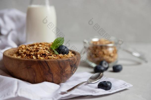 牛奶什锦早餐或燕麦片格兰诺拉麦片采用一木制的碗紧接在后的向一瓶子关于英语字母表的第6个字母