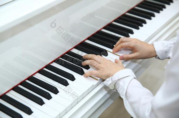 小的男孩演奏指已提到的人<strong>钢琴</strong>在家.白色的<strong>钢琴</strong>.阿塞拜疆