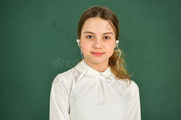 学生女孩采用耳机在黑板背景复制品空间.
