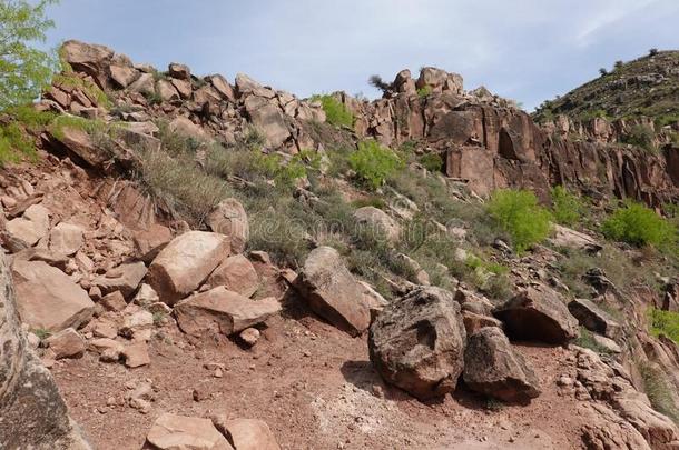 红色的砂岩岩石向一多岩石的小山