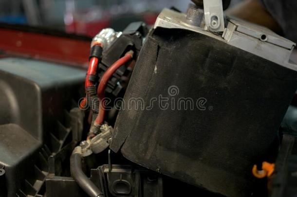 汽车服务工人安装蓄电池进入中一c一r发动机.
