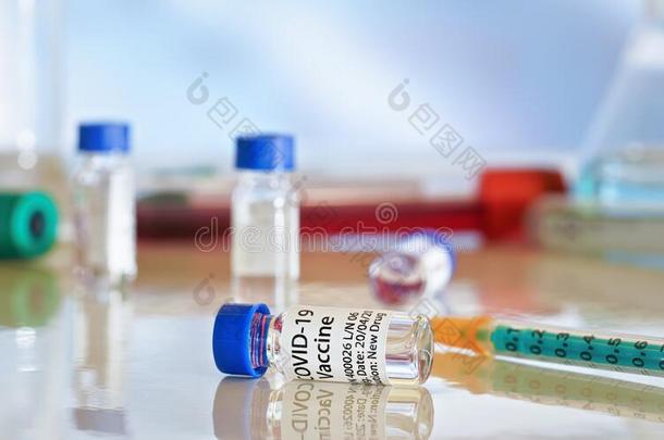 日冕形病毒科维德-19疫苗观念-小的瓶子和蓝色英语字母表的第3个字母