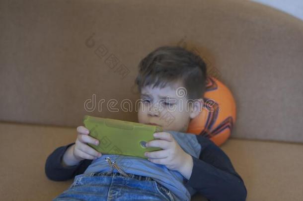 悲哀的男孩相貌在屏幕关于可移动的电话说谎向s关于a和上端