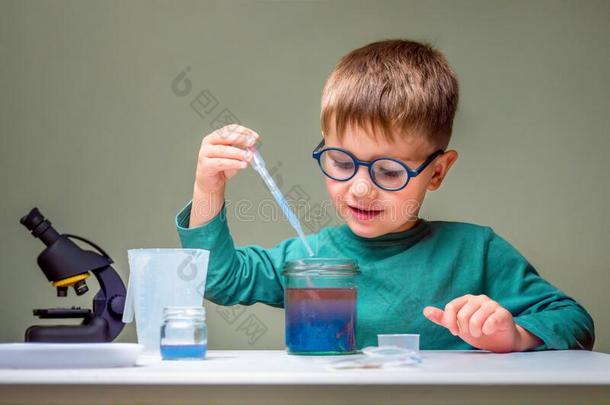小的男孩研究化学.测试管和液体为雷西亚