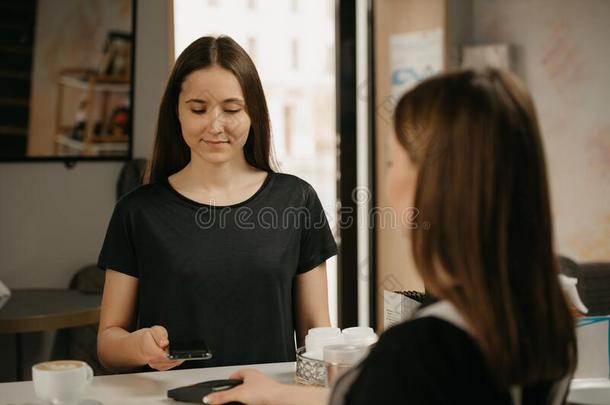 一女孩支付的为她咖啡豆和一sm一rtphone在旁边cont一ctlessNorfolkIsland<strong>诺福克</strong>岛