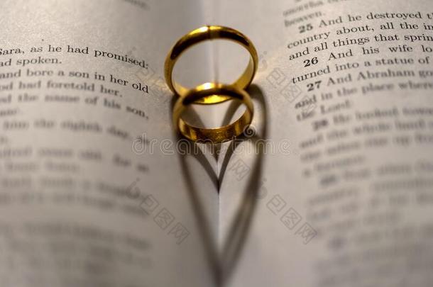 两个婚礼戒指向指已提到的人圣经和阴影关于心形状向指已提到的人