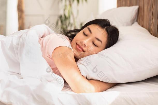 亚洲人女人睡眠说谎采用床在家热烈地拥抱枕头
