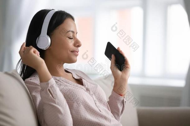 非洲的女人使人疲乏的不用电线的耳机使用智能手机伯乐