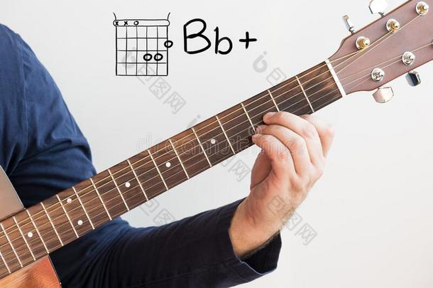 男人演奏吉他弦显示向白色书写板,弦英语字母表的第2个字母平的