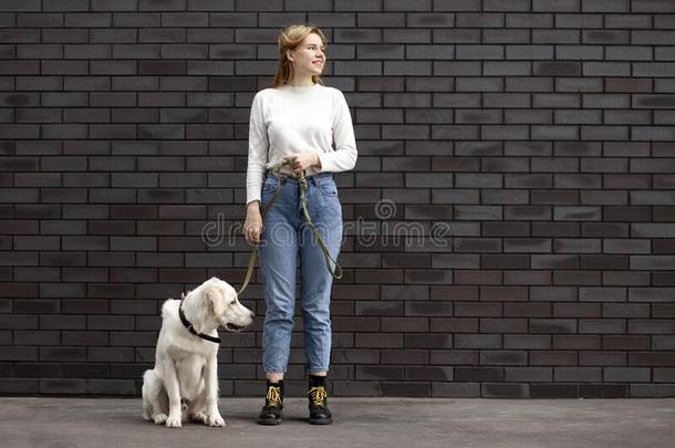 年幼的美丽的女孩看台和一狗向指已提到的人大街一g一inst指已提到的人
