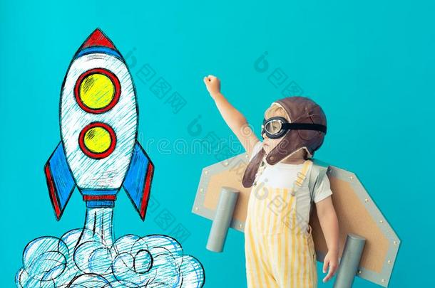 幸福的小孩演奏和玩具纸飞行章反对蓝色背景