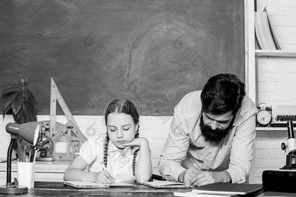 学习同时.有胡须的男人教师和小的女孩采用教室
