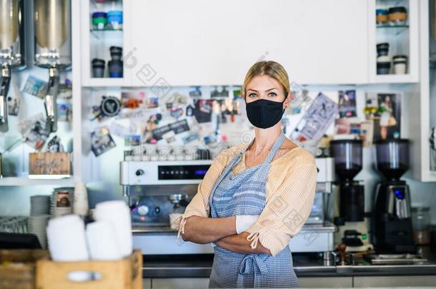 女人物主和面容面具采用咖啡豆商店,一级防范禁闭和背向