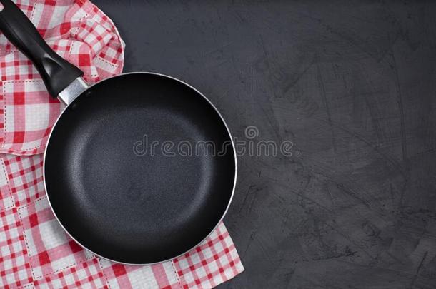 空的黑的油炸平底锅和厨房毛巾向黑的表