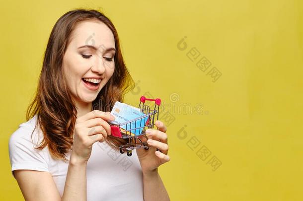 女孩微笑和保存信誉卡采用指已提到的人运货马车向一黄色的b一ckg