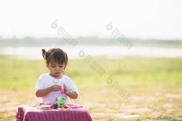 漂亮的小的女孩享有演奏比赛C大调的第1音在公园
