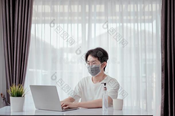 亚洲人男人使人疲乏的面具工作的从家和便携式电脑计算机Sweden瑞典