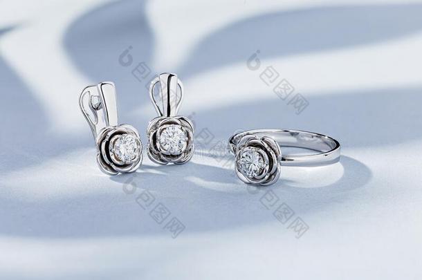 珠宝放置关于钻石耳环和戒指向彩色粉笔蓝色后台