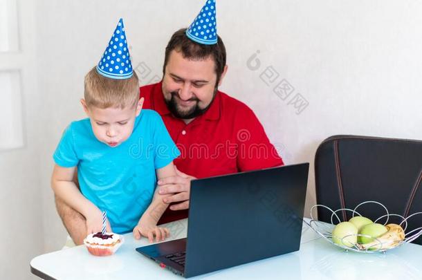 小的男孩和他的父亲庆祝生日在线的,讲话在旁边