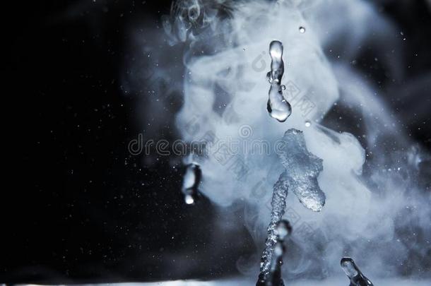 炎热的水溅起和蒸汽向黑的背景特写镜头
