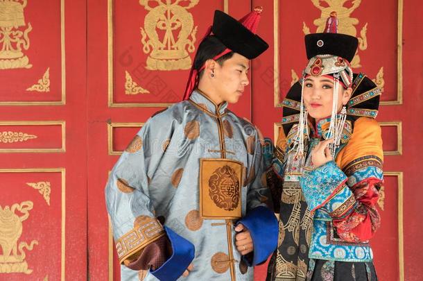 年幼的蒙古的对采用一老的蒙古的戏装.