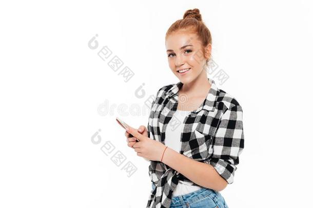 微笑的<strong>姜</strong>女人采用衬衫和牛<strong>仔</strong>裤hold采用g智能手机
