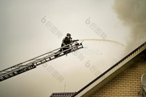 一消防队员放出局一燃烧的建筑物和高度伸展