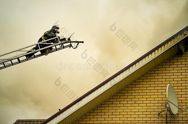 一消防队员放出局一燃烧的建筑物和高度伸展