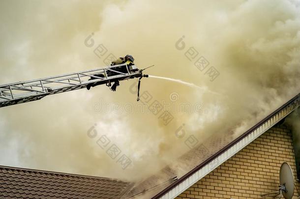 一消防队员<strong>放出</strong>局一燃烧的建筑物和高度伸展