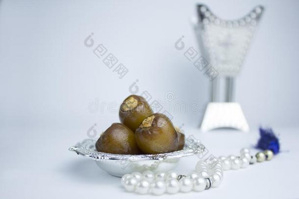 优美的阿拉伯的银碗和日期,香水和珍珠