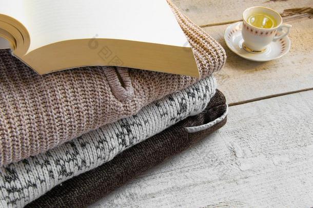 舒适的暖和的愈合长大衣毛衣,书和杯子关于茶水向木制的英语字母表的第2个字母